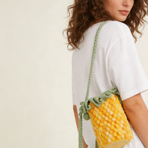 the pineapple crochet crossbody bag, a versatile fruit themed eco friendly bag made of snowfei thread. it is golden in color and has a slanted design. it is cute, knitted with wool, unique, suitable for giving as a gift or for personal use. babies can store snacks in it, adults can put their phones and cosmetics in it, and it can also be used as a portable bag for wet wipes and tissues.