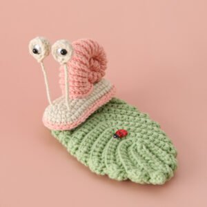 hand knitted snail & leaf phone stand, soft cotton yarn, unique whimsical charm, safe & functional decor, meaningful nature inspired keepsake